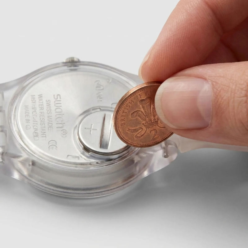 Swatch caseback with a coin in the slot showing how the coin-slot caseback opens